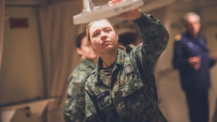 Militair bekijkt medische apparatuur aan boord van schip.