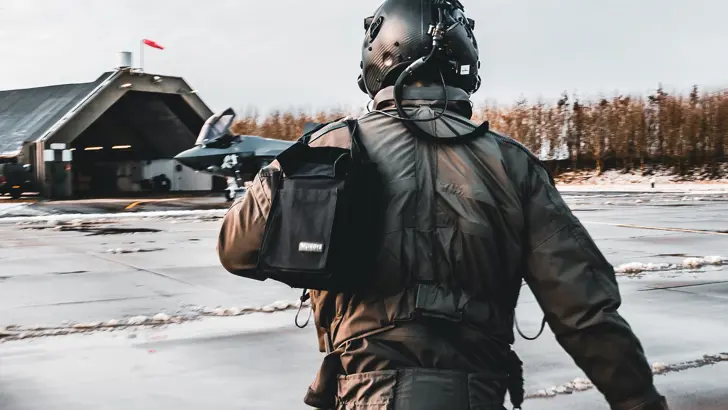 / Een vlieger op de rug op weg naar een klaarstaande F-35.