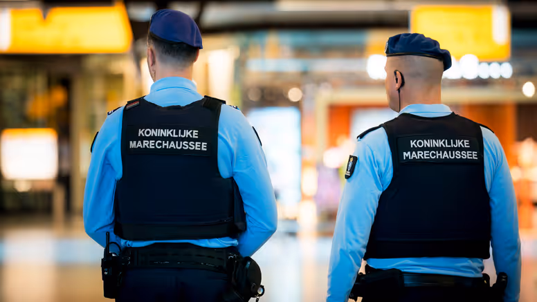 Twee marechaussees in operationeel tenue, op de rug gezien.