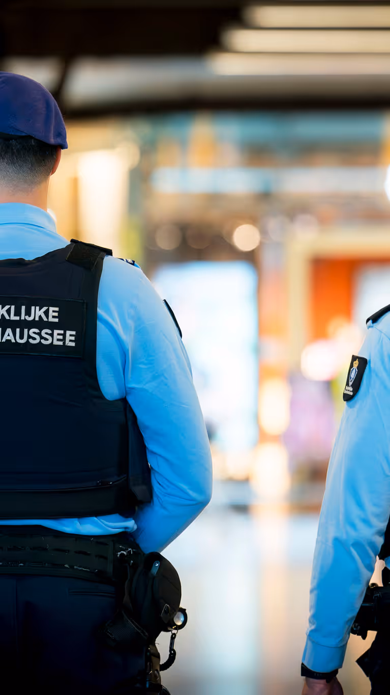 Twee marechaussees in operationeel tenue, op de rug gezien.