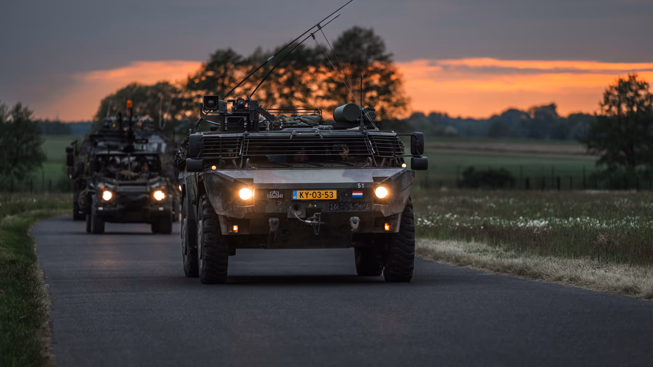 Personeel staande bij de Tracking Antenna Rotators met een drone hoverend op de voorgrond. 