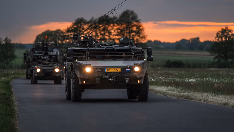 Personeel staande bij de Tracking Antenna Rotators met een drone hoverend op de voorgrond. 