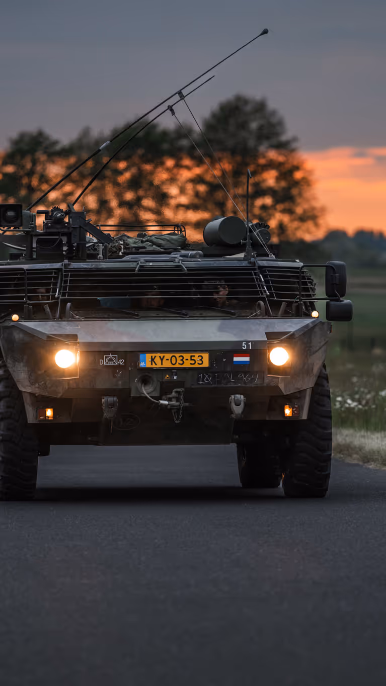 Personeel staande bij de Tracking Antenna Rotators met een drone hoverend op de voorgrond. 