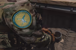 Logo van NAVO-missie op schouder van militair.