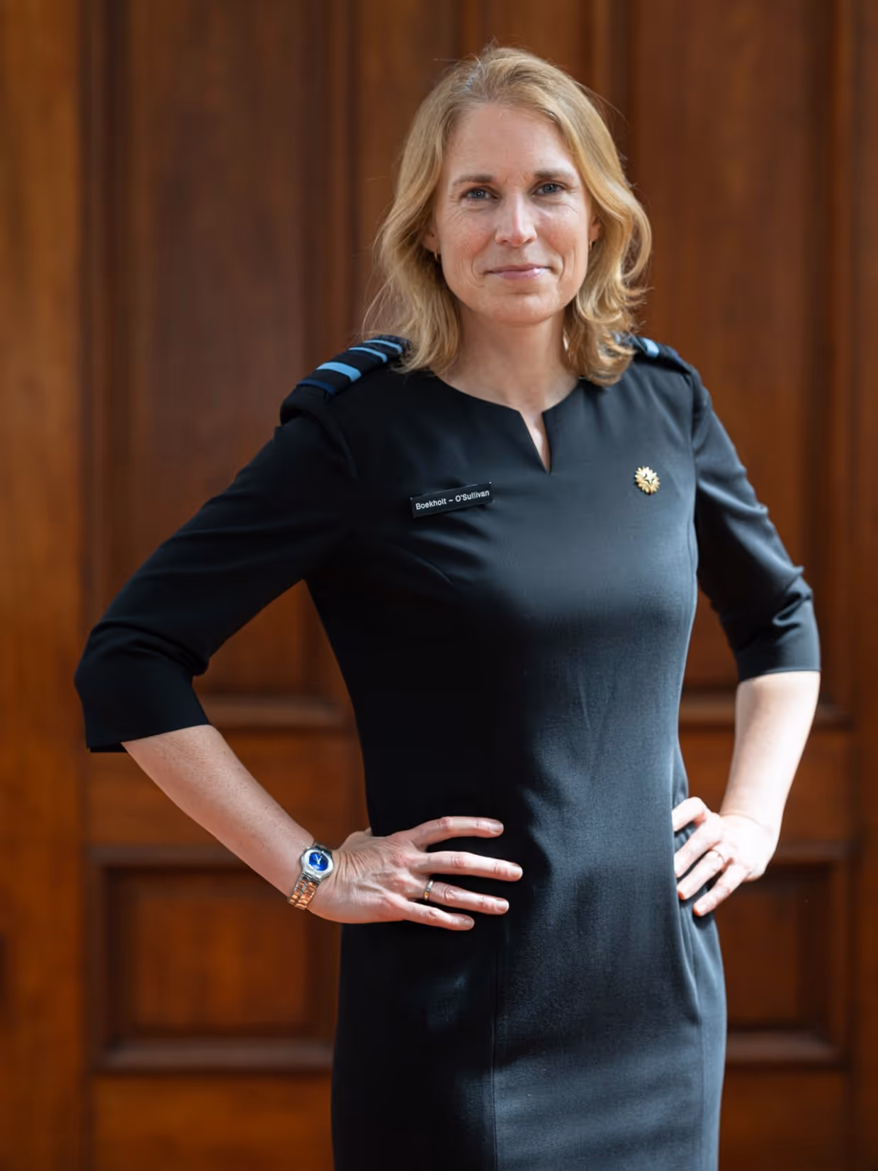 Boekholt-O’Sullivan staat met haar handen in haar zij. Ze draagt een zwarte jurk met rangonderscheidingstekens. 