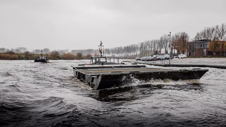 Ponton met oude vaartuig op de achtergrond.