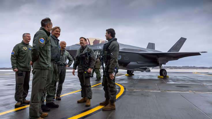 Koning Willem-Alexander praat met groep soldaten staand voor een F-35.
