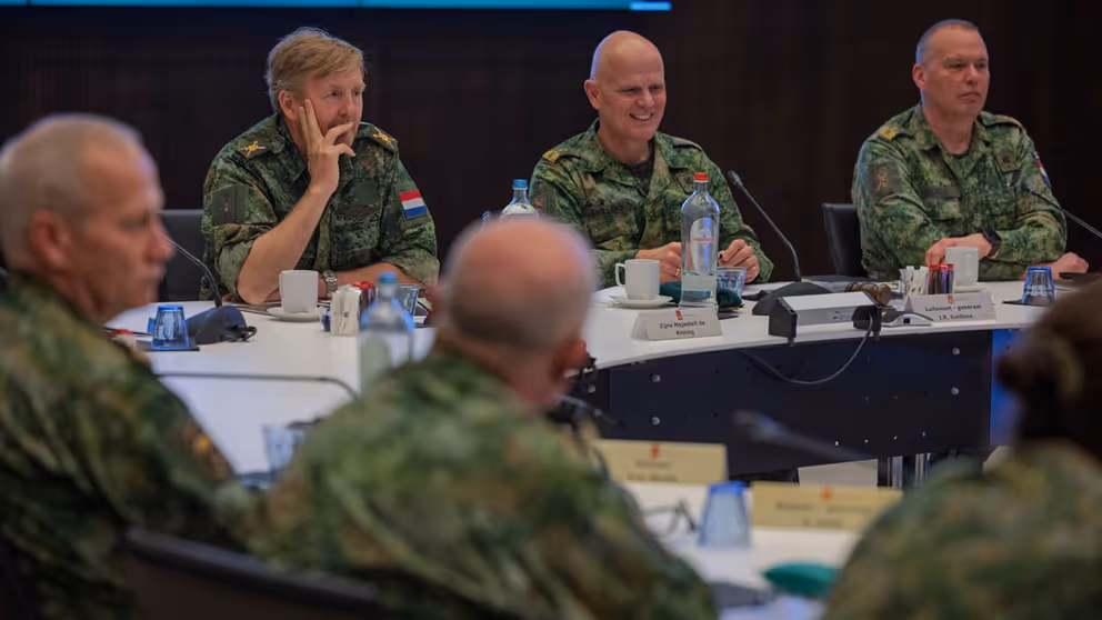 Koning zit aan tafel met Landmachtraad.