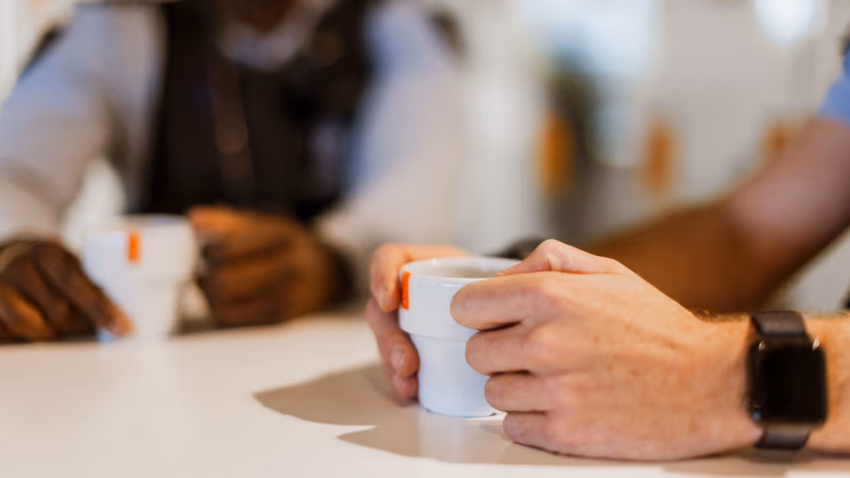 Marechaussee met een koffiekopje in zijn hand.
