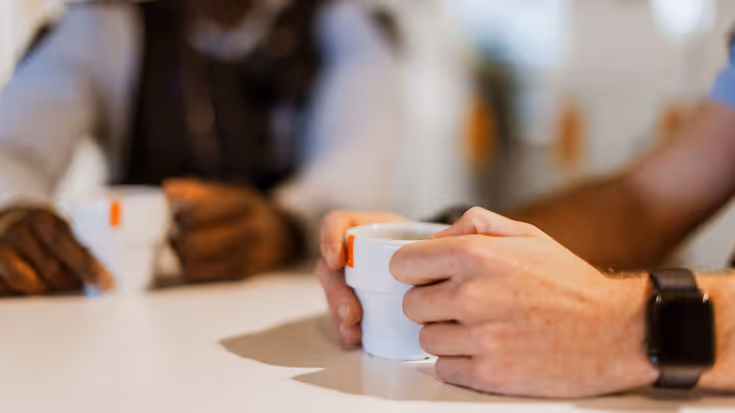 Marechaussee met een koffiekopje in zijn hand.