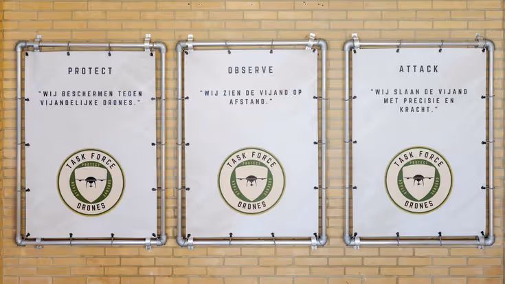 Een muur met daarop 3 afbeeldingen van de taakgroep drones.