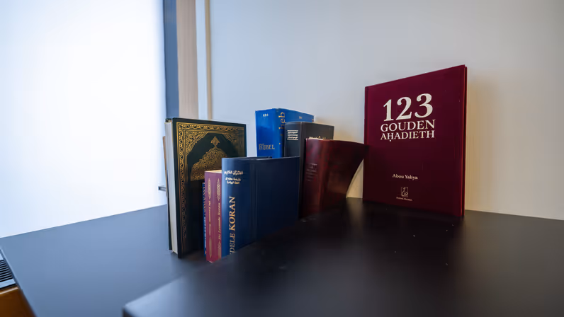 Een kast met daarop heilige boeken van diverse religies.