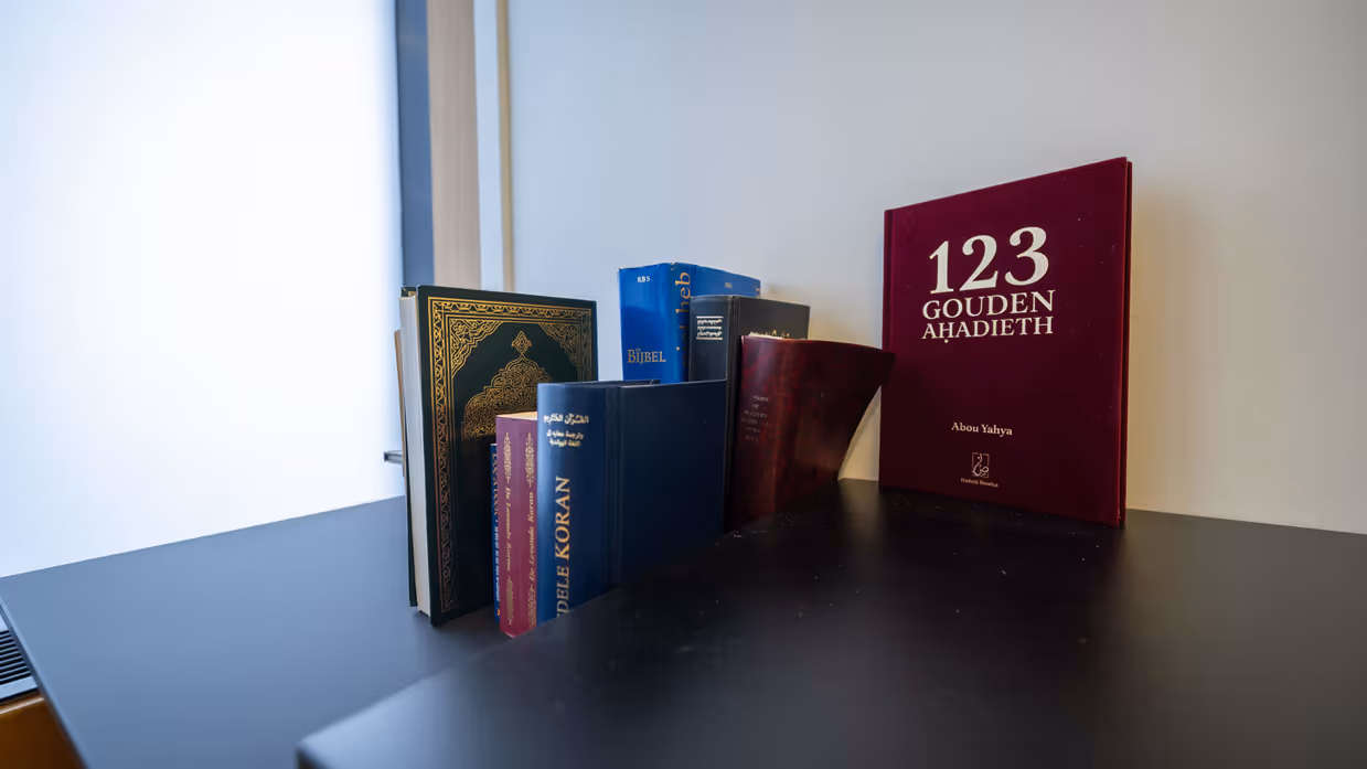 Een kast met daarop heilige boeken van diverse religies.