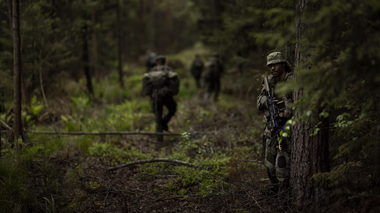 Een groep militairen loopt door het bos.