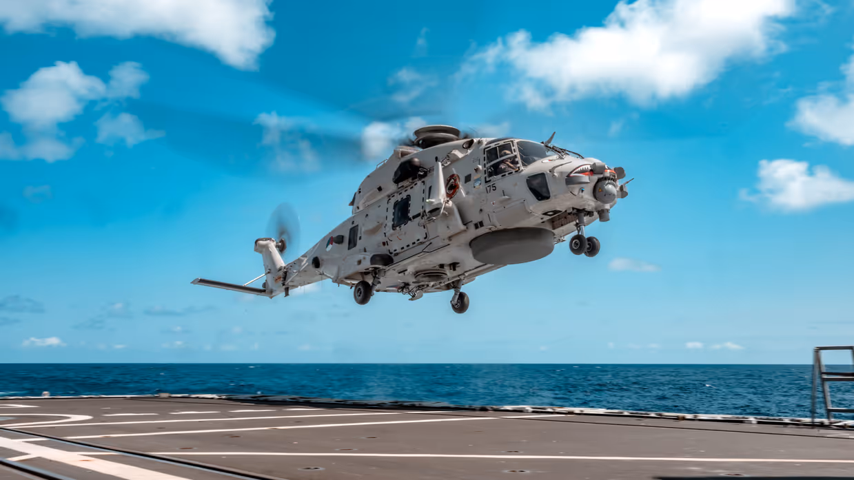 NH90 vlak boven een vliegdek van een schip op zee.