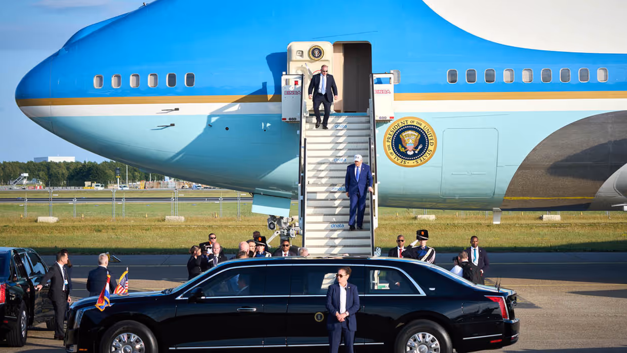 President Trump daalt vliegtuigtrap af om in auto te stappen.