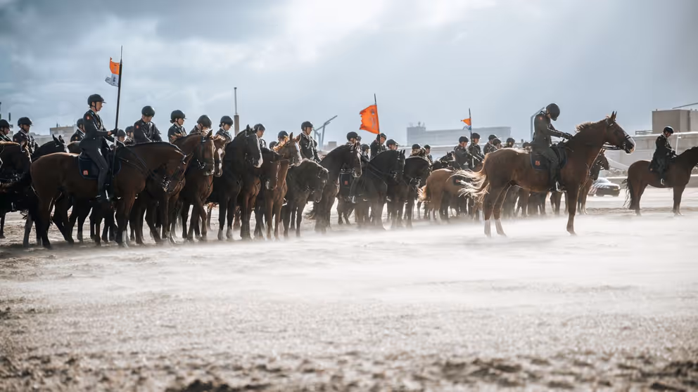Ruiters te paard op het strand.