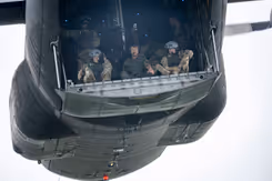 Parachutisten zitten klaar om uit het vliegtuig te springen. In het midden de koning.