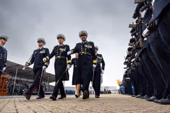 5 mariniers lopen langs een erehaag. 