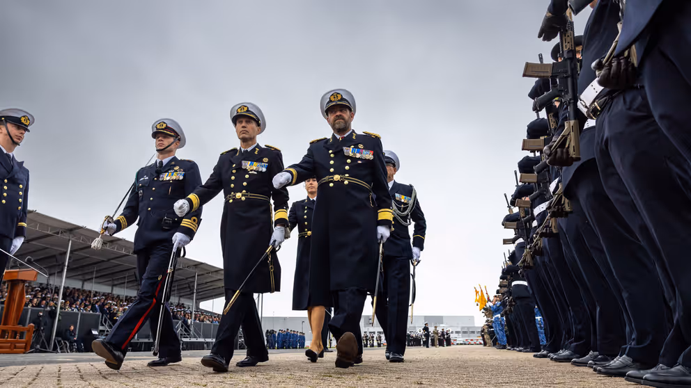 5 mariniers lopen langs een erehaag. 