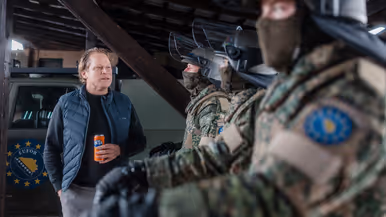  Staatssecretaris Tuinman praat met militairen in ME-tenue. Minister Brekelmans praat met een groepje marechaussees op Schiphol.