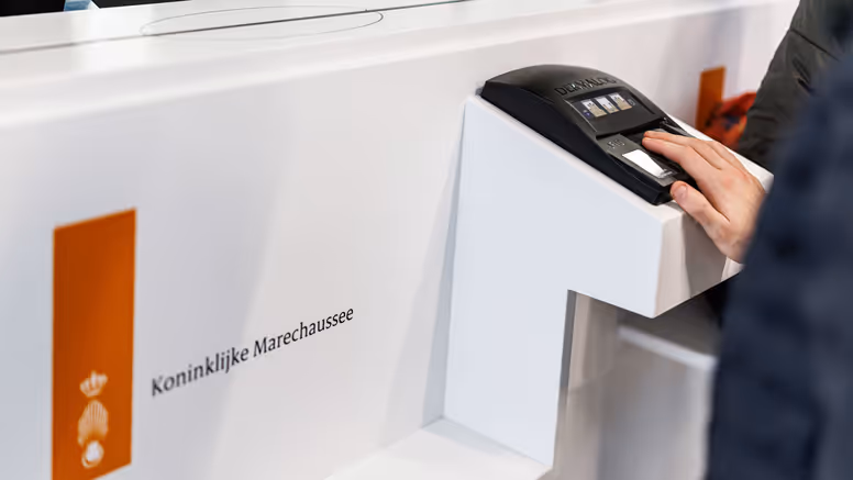 Een passagier geeft zijn vingerafdruk af.