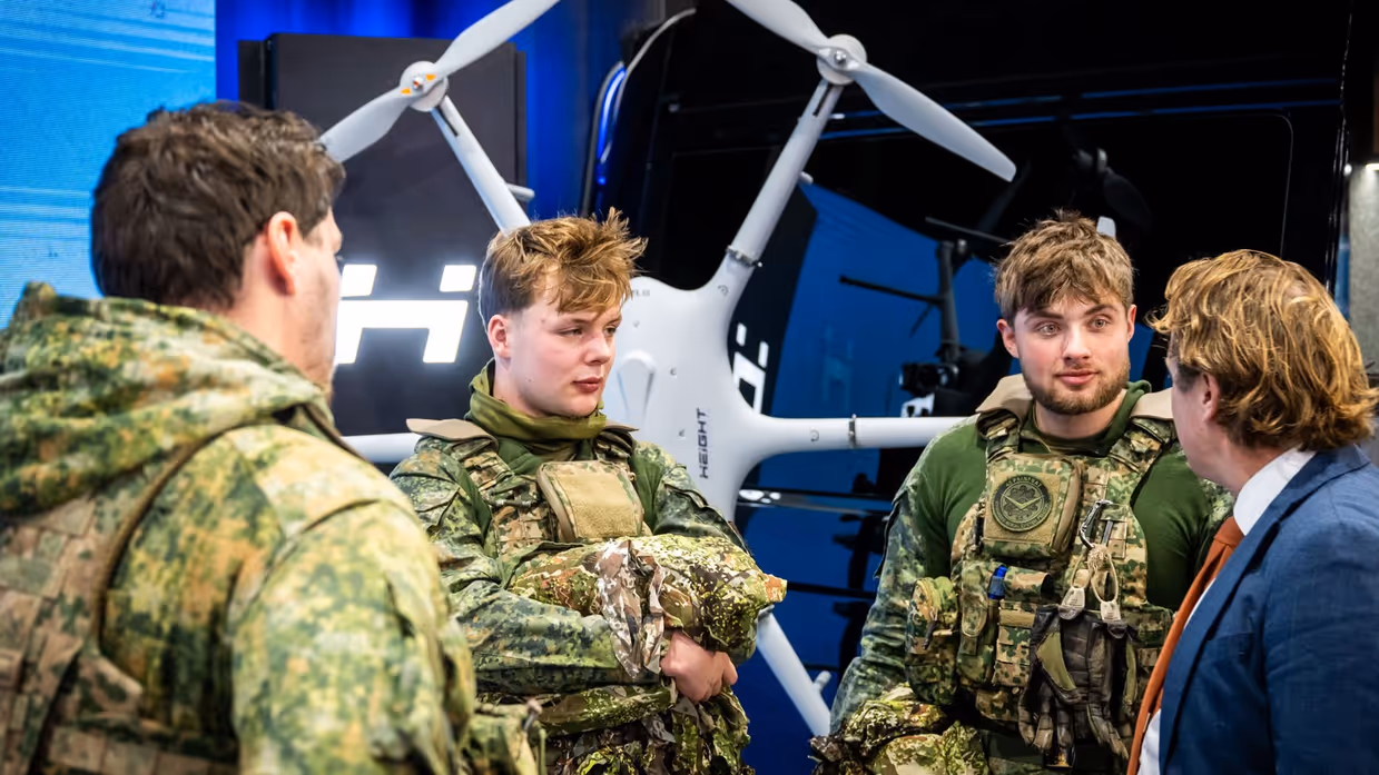 Tuinman in gesprek met 3 jonge militairen.