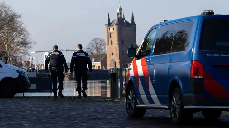 Twee marechaussees lopen op straat.