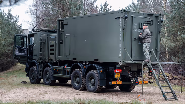 Militair achterop een stilstaande truck.
