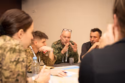 Militairen in gesprek aan een tafel.