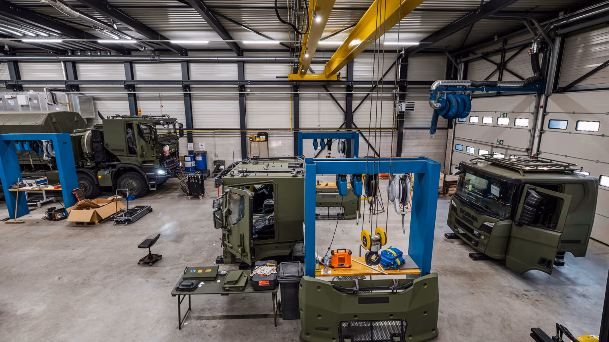 Werkplaats waarin gewerkt wordt aan grote militaire transportvoertuigen.