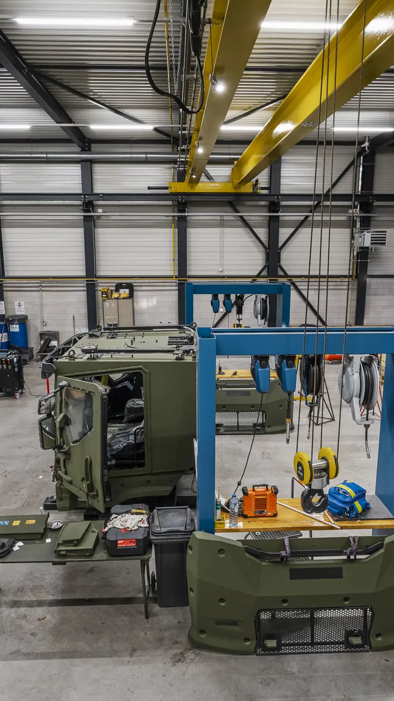 Werkplaats waarin gewerkt wordt aan grote militaire transportvoertuigen.