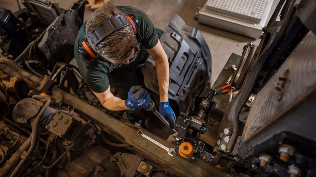 Monteur sleutelt aan chassis transportvoertuig.