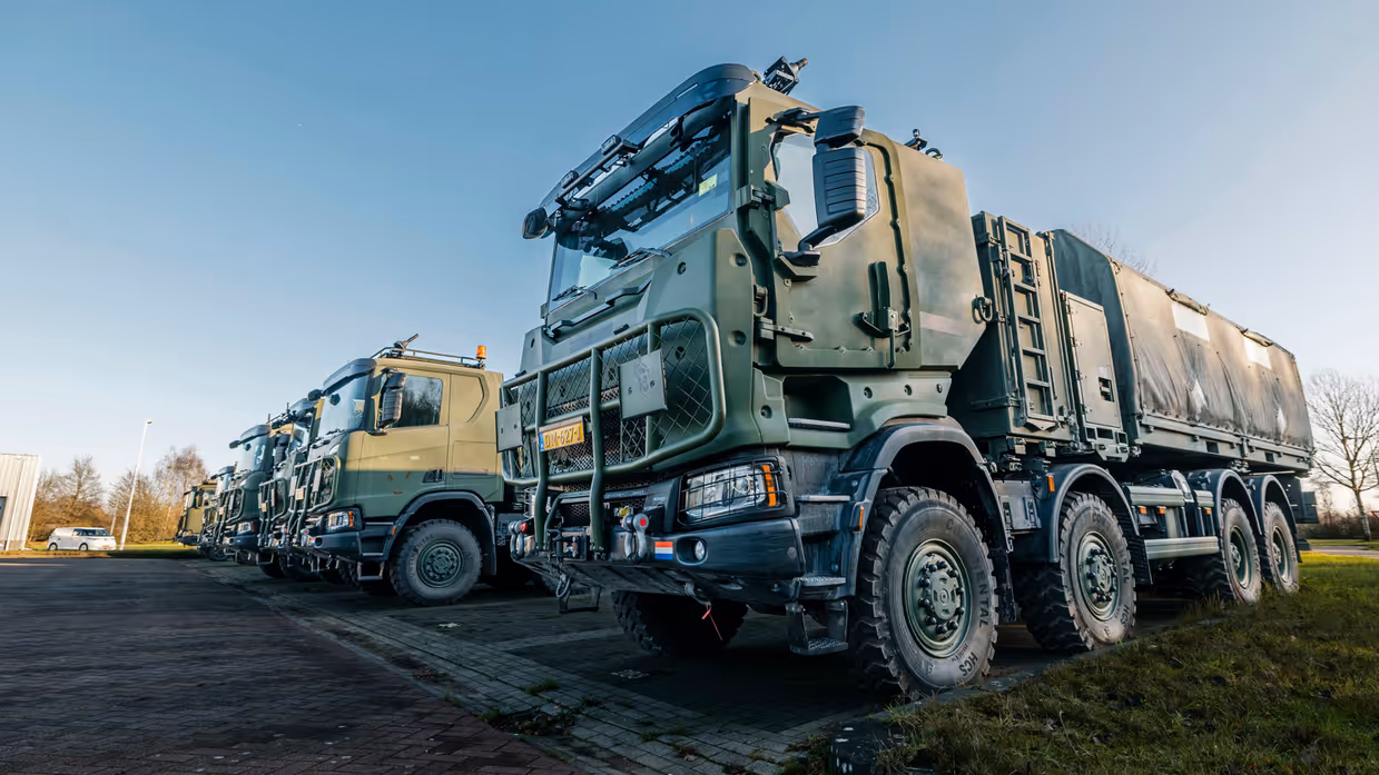Bepantserde transportvoertuigen staan naast elkaar op parkeerplaats.