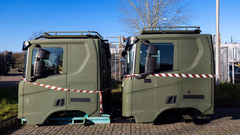 Twee losse cabines van transportvoertuig op parkeerplaats.