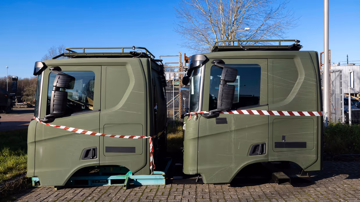 Twee losse cabines van transportvoertuig op parkeerplaats.