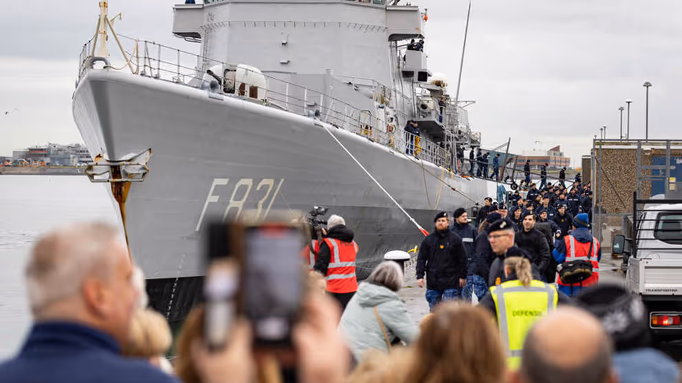 Mariniers lopen op de wal naast Zr.Ms. Van Amstel. 