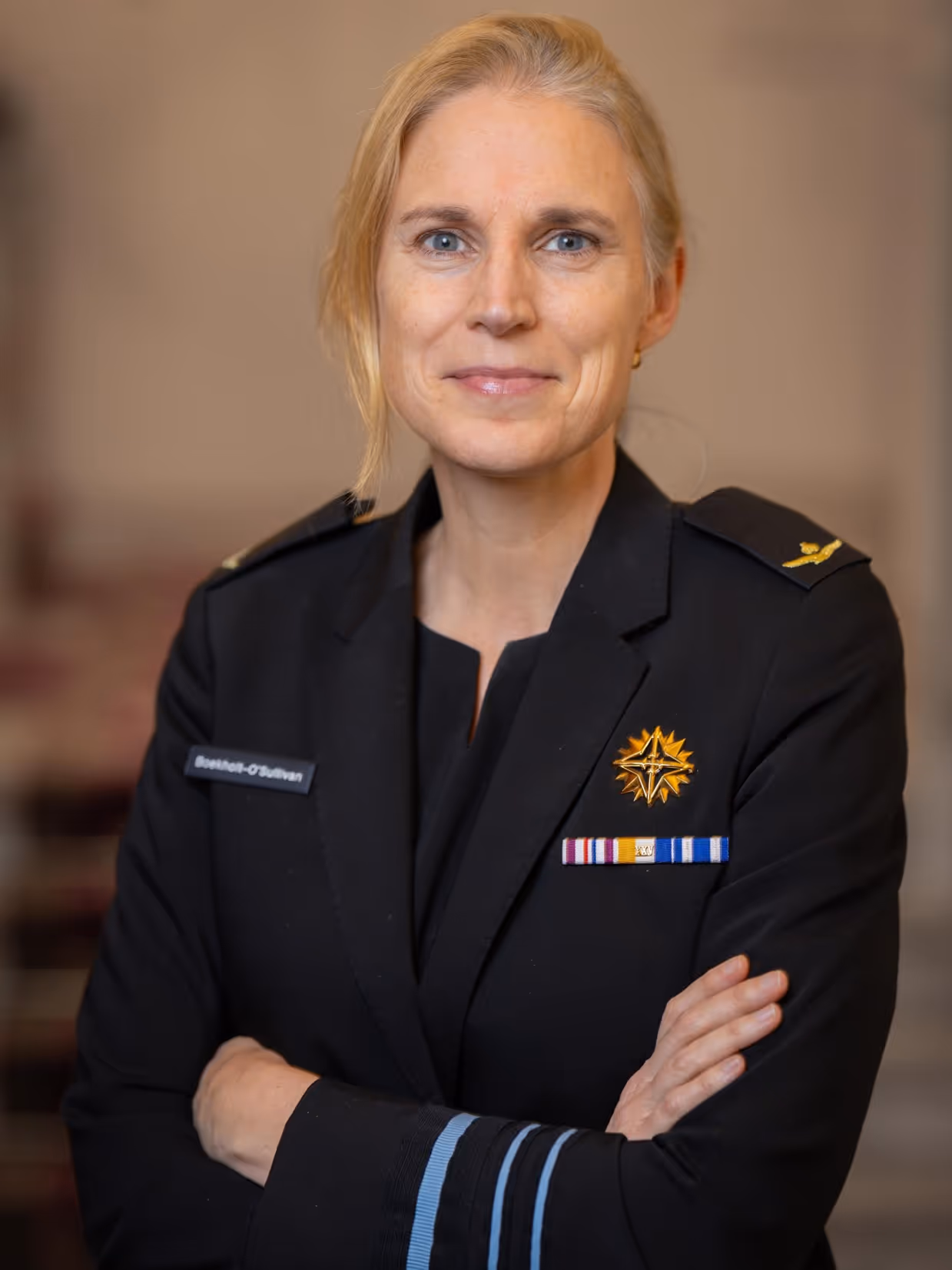 Boekholt-O’Sullivan geeft premier Jetten een hand. Op de andere foto is ze nog te zien in een donker defensie-uniform.