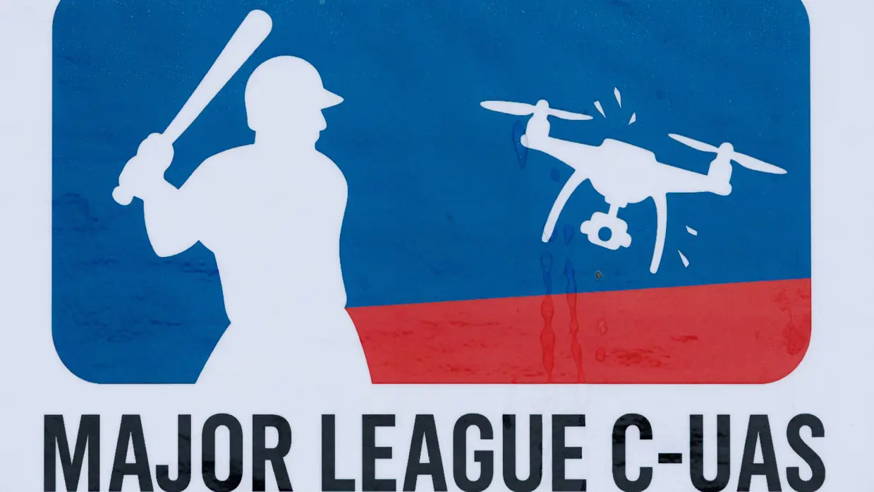 Een logo van een honkbalspeler die naar een drone slaat.