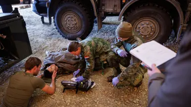 Militairen verzorgen een gewonde collega.