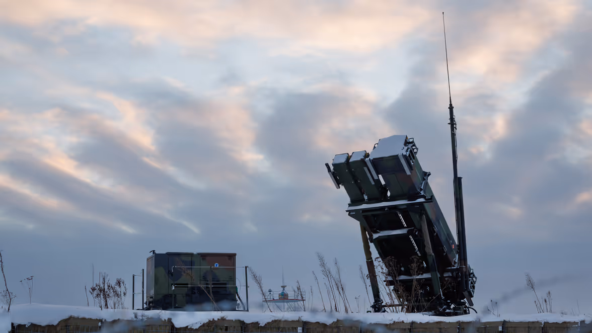 Een Patriot- lanceerinrichting gericht naar de grijze lucht. Er liggen verschillende lanceerbuizen op voor verschillende typen raketten. Op de foto staan blauwe bolletjes. Wie hier op klikt kan meer informatie lezen over het wapensysteem.