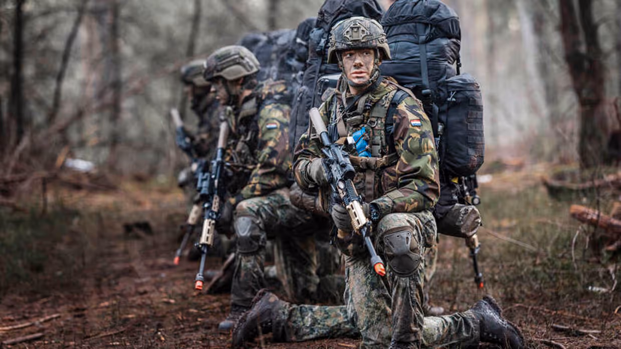 Deelnemers aan de NWT zitten op hun knieen in het bos.
