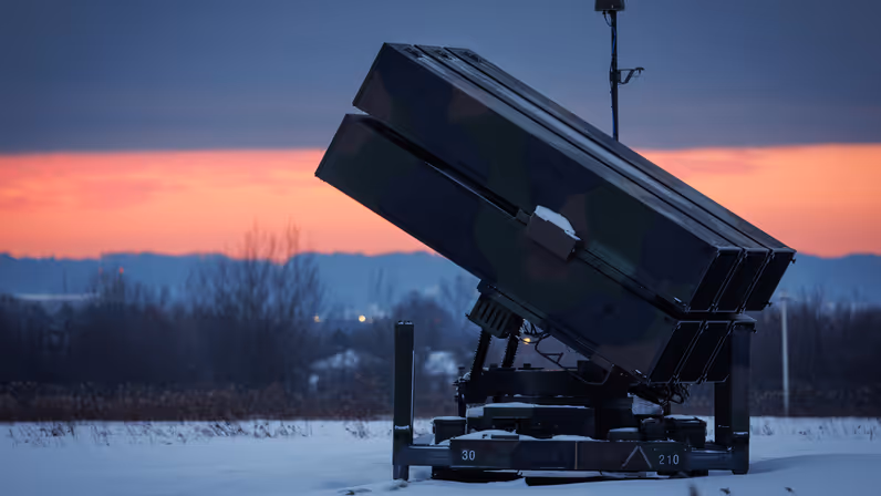 Een NASAMS-lanceerinstallatie tegen een rode ochtendlucht.