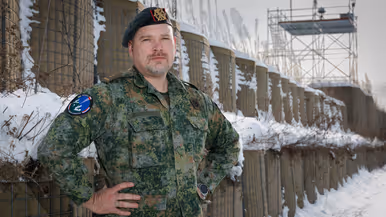 Een portretfoto van commandant Dijkshoorn met zijn armen in zijn zij. 