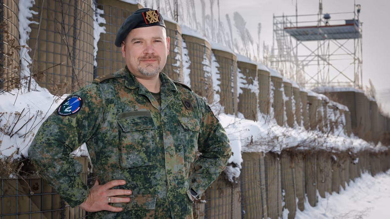 Portretfoto van commandant Dijkshoorn buiten in de sneeuw, met zijn handen in zijn zij.