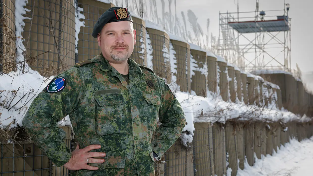 Portretfoto van commandant Dijkshoorn buiten in de sneeuw, met zijn handen in zijn zij.