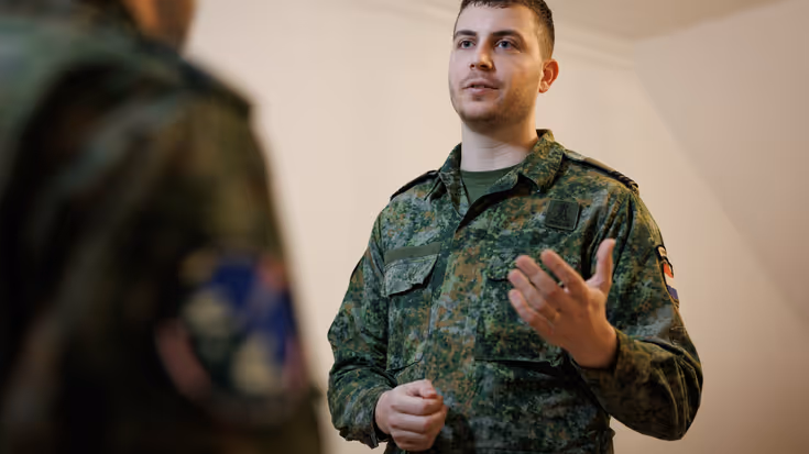 Portretfoto van Dani in gesprek met een collega-militair.