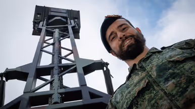 Een portretfoto van Jimmy met een radar op de achtergrond.