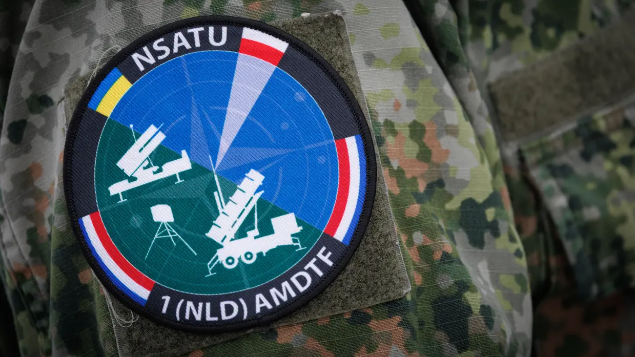 Het logo van NSATU met daarop alle wapensystemen en vlaggen van Oekraïne, Polen en Nederland. 