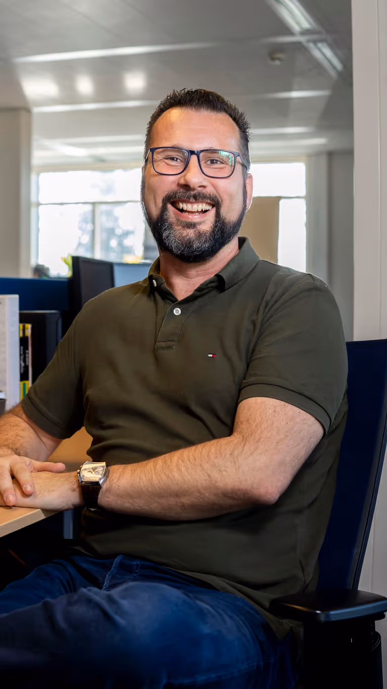 Marcel Pelster zit achter zijn bureau terwijl hij in de camera kijkt.